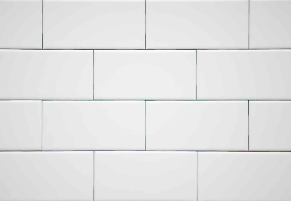A master tiler carefully placing a large format tile on a floor